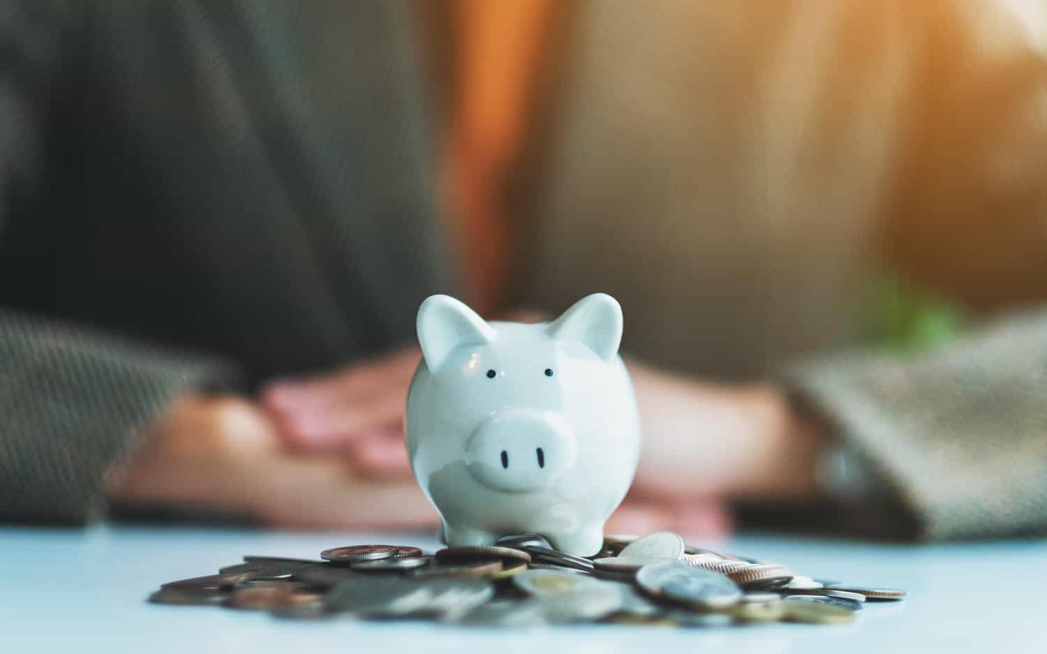 closeup image of a woman and piggy bank on pile