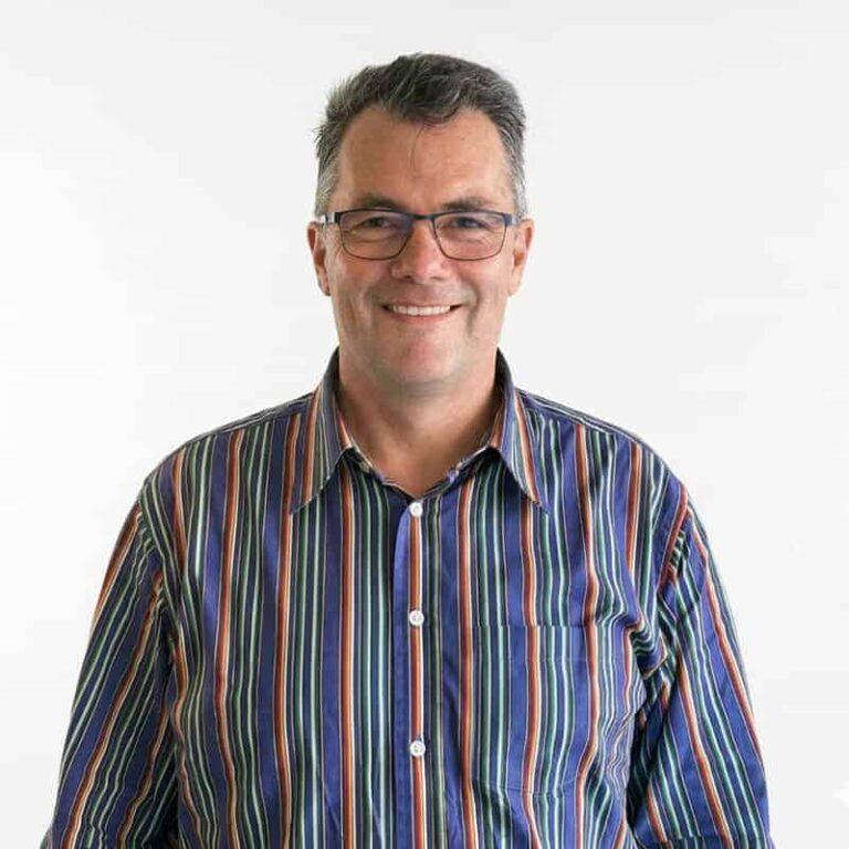 Hein Preller, Director at Superannuation Warehouse, smiling in a striped shirt against a plain background, reflecting his role in managing the accounting practice.