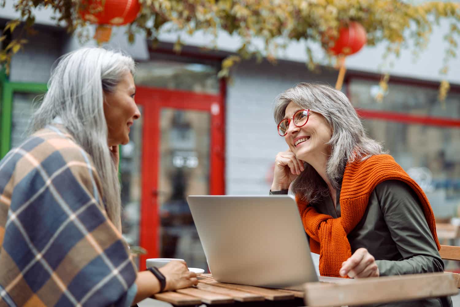 grey haired lady with laptop spends time